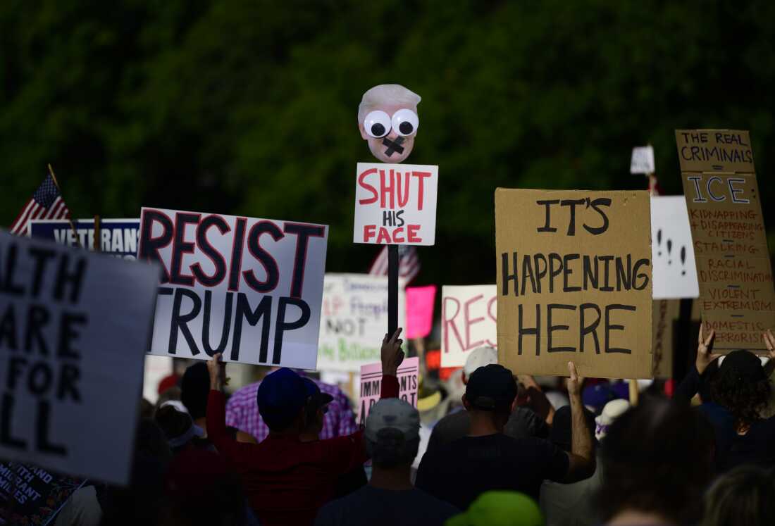 Protesters hold signs during a protest.