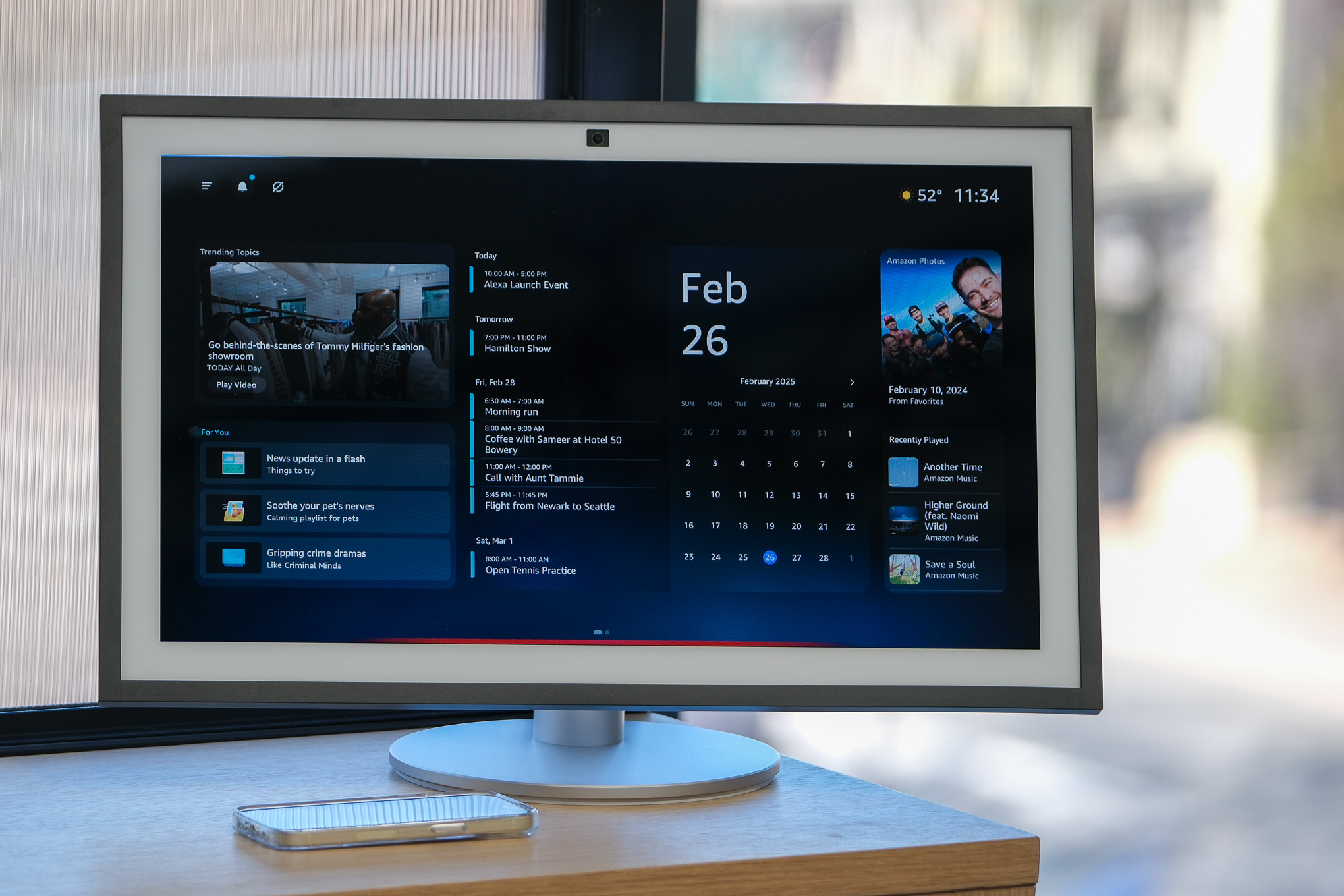 An Echo Show smart display on a table in front of a window.