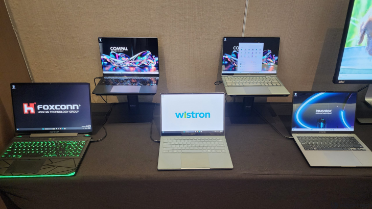 Five laptops on display with logos: Foxconn, Compal, Wistron, Inventec, on a table at an event.